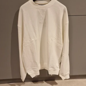 Hugo Boss Vit Sweatshirt i "L" - Oanvänd, finns kvar i sin förpackning och etiketten sitter kvar. Skriv vid eventuella frågor eller funderingar  Finns i Linköping 
