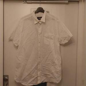 Stilren vit kortärmad skjorta från dressman med storlek 2XL. Skön och andas, bra kvalitet och bra skick
