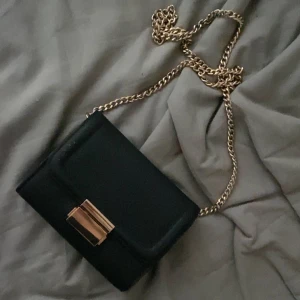 Axelremsväska  - Säljer min jättefina axelremsväska då den inte används. Svart med guld detaljer 