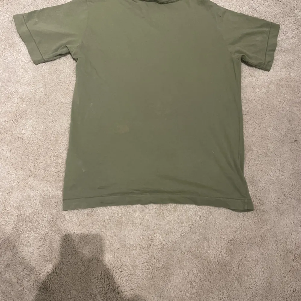  Säljer denna mörkgröna Stone Island t-shirt i bra skick ett pytte litet hål som knappt syns tröjan Är i storlek tolv år / 156 cm nypris 800 till 1000 skriv vid intresse!. T-shirts.