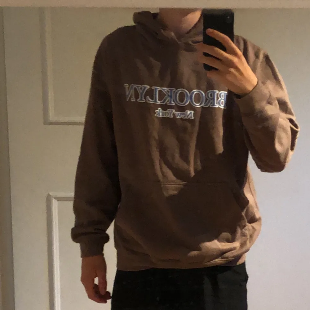 Baggy fit brun hoodie me blå text, helt oanvänd. Hoodies.