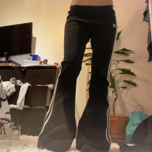 Adidas bootcut byxor - De perfekta adidas byxorna som är flare/bootcut  Midjemått: 36cm (mätt rakt över) Innerbenslängd: 79cm