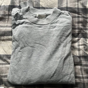 Grå tröja  - Grå tröja med slits på sidorna. Bra skick då den är använd 2 gånger. 
