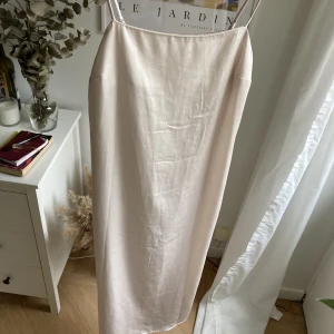 Silkesklänning - Väldigt ljus rosa silkesklänning från H&M! Den är i nyskick då den bara är använd 1 gång. Slits på ena sidan. Passar både XS och S.