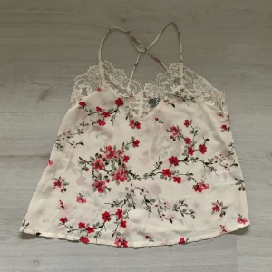 Blommigt spetslinne - Blommigt linne med spets från Ginatricot. Den har justerbara band och är i bra skick. Nypris 199kr. Storlek S.