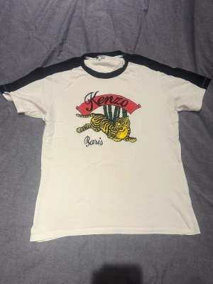 Kenzo T-shirt - Säljer nu min Kenzo T-shirt pågrund av att jag inte använder den längre, storlek L men passar M och sitter lite oversized på de som i vanliga fall har S. Tröjan är köpt på NK i Göteborg  för 1300 och är varsamt använd dvs mycket bra skick.