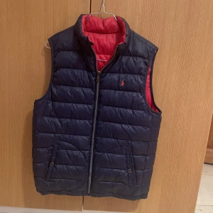 Ralph Lauren väst - Säljer denna Ralph Lauren väst. Går att använda den som marinblå men även röd/orange. Storlek S men funkar för både större och mindre storlekar. Köpt för 2399kr men säljer för 850kr. 