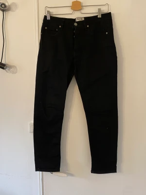 Acne Jeans  - Svarta Jeans från Acne. Modell: Town Stay Cash Strl: 29/32 Liten spricka bak som enkelt sys ihop. 