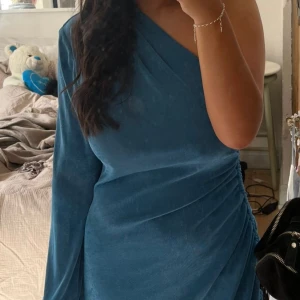 Fin klänning - NAKD x Angelica Blick storlek S Nypris 600kr, mitt pris 350-500kr, använd 1 gång Klänning är väldigt töj bar och skulle säg att den hade kunnat passa upp till m/ liten L Den har en scrunch vid högra sidan Den är också lite shimrig i tyget, väldigt fin