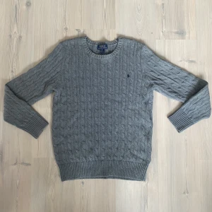 Stickad Ralph Lauren Tröja - Grå stickad Ralph Lauren tröja.  - Använd fåtal gånger  - Annorlunda storlekar -  XL (18-20) 