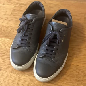 Arigato sneakers  - Arigato leather sneakers i mörk grå färg, använda men bra skick