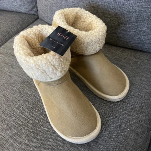 Hunkemöller tofflor - Tofflor från hunkemöller. Helt nya och oanvända. Säljer då de är för små för mig. Supersköna och varma. Fungerar att använda både inne och ute då de har en sula. Prislapp finns kvar. Ordinarie pris 299kr