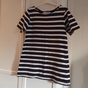 T-shirt - A-linjeformad t-shirt, mörkblå och vit-randig.  100% bomull. 