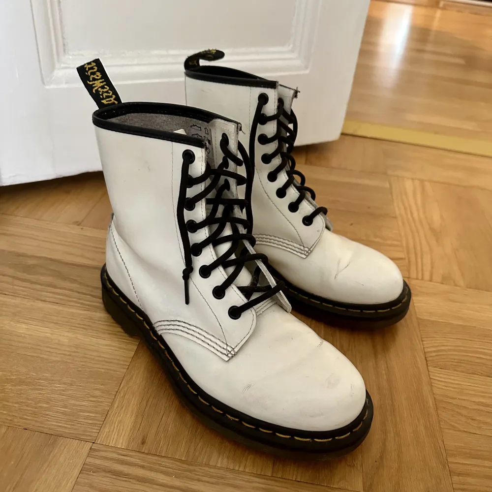 Vita Dr Martens i fint skick! Snygga till både byxor och klänning. Har en liten reva på baksidan på baksidan, se bild. . Skor.