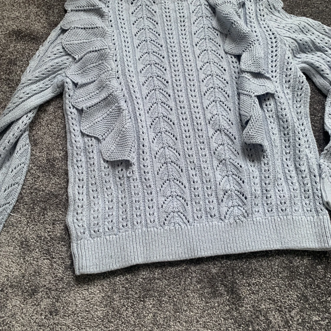 Blå stickad tröja med volang  - 91