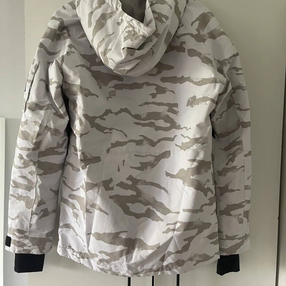 Superfin skid/snowboardjacka i vit/grå camouflage. Använd en säsong i strl s. Takit.