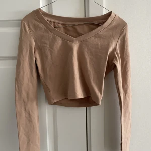 V ringad topp - En v ringad beige topp som är så fin till lågmidjade jeans eller kostymbyxor!