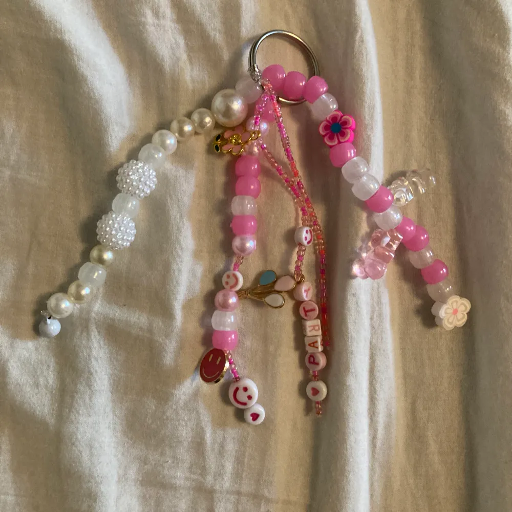 En jättefin rosa nyckelring men pärlor, bubblepärlor, berlocker, smileys och blommor. 🤩🩷 5 stränger.. Accessoarer.