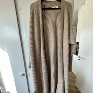 Kofta - Beige kofta, är nedanför knäna på mig som är 170, jätte mysig, delvis ull, använd 2 ggr