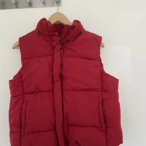 Röd väst - Röd dunväst från amica. Storlek 44 men känns som en M/L