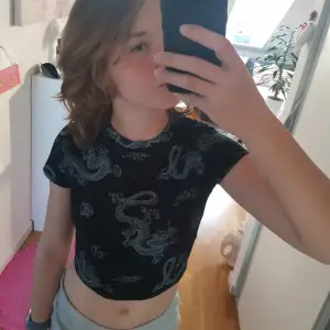 Black crop top with white drogon animation. Super cute, a tight fit and is comfortable. Also fits with everything!
