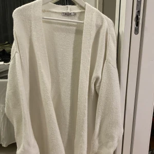 NA-KD lång stickad kofta - Vit lång stickad kofta från nakd, storlek S.