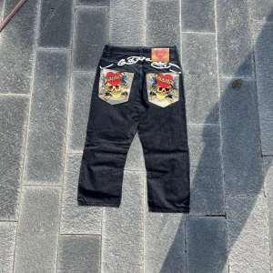 Ed Hardy Jeans  - Längd: 92cm Midja: 40 cm Innerben:57 cm Benöppning: 22cm Har aldrig använt dem eftersom de var för korta för mig och jag är 184 cm. Skulle vara perfekt för någon runt 177-168cm lång +- Enda defekten är vid patchen men det påverkar inte jeansen som helhet.