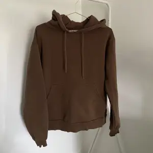 En brun hoodie från NA-KD. Storlek S. 
