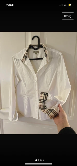 Burberry skjorta - Äkta Burberry, figursydd damskjorta. I storlek L men en aning mindre i storlek. OBS. Finns inget kvitto eller ”dustbag”