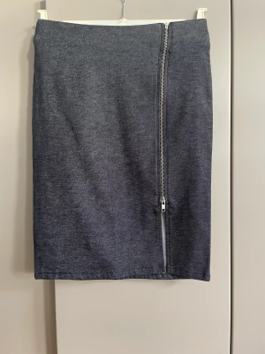 Kjol 34 - Oanvänd  Midja 70 cm Längd 52 cm
