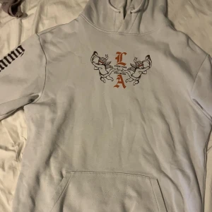 Vit hoodie med tryck - Vit hoodie med coolt tryck och text, från H&M. Perfekt inför hösten och sitter riktigt bekvämt! Har katt i hemmet och fråga gärna om mått eller fler bilder!