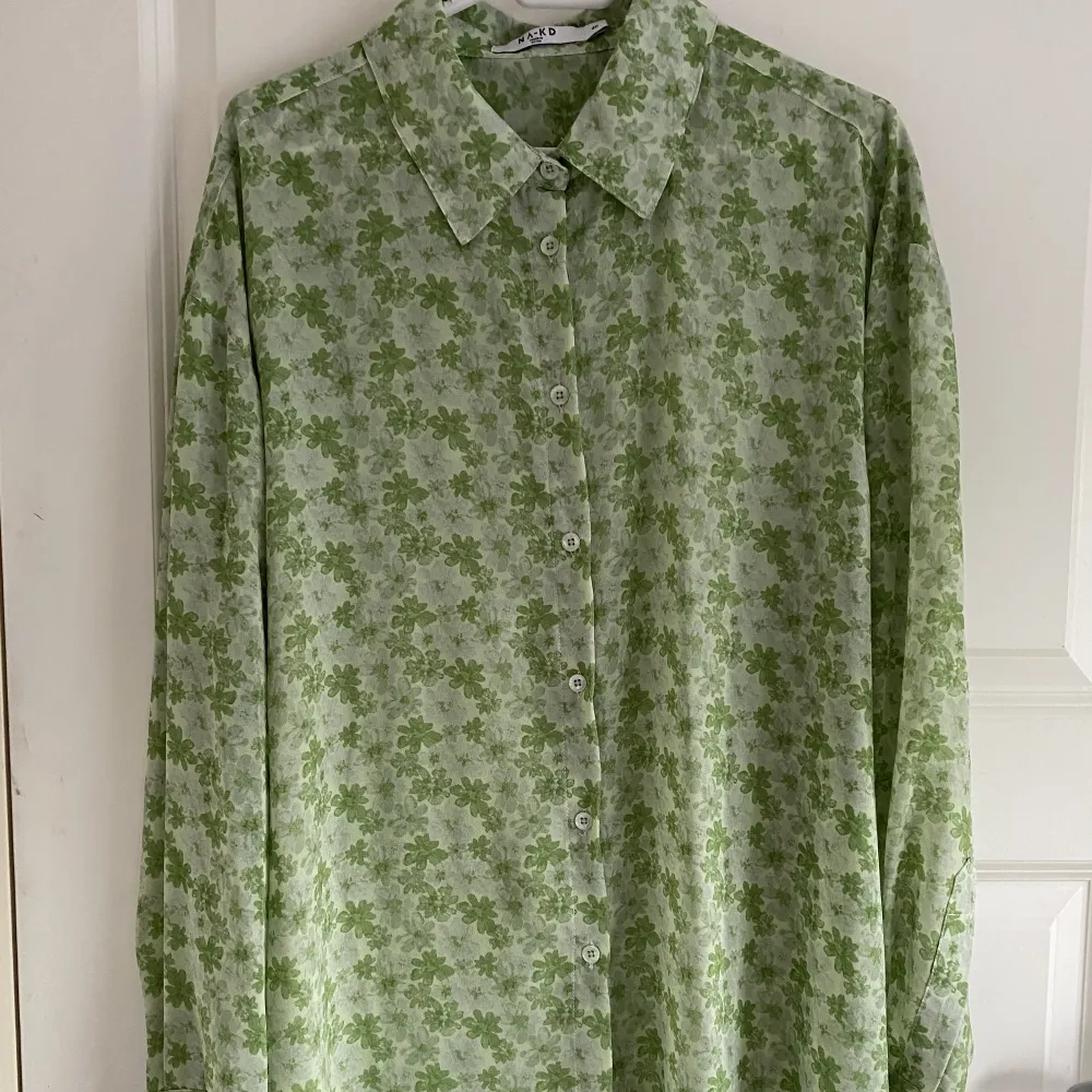 Recycled oversized skjorta i grön färg med blommigt mönster. Den är i polyester och är transparent. Den är oanvänd & som ny!. Skjortor.
