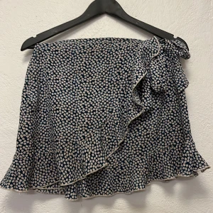 Kjol - Blommig kjol med dragkedja och knutdetalj. Använd men i bra skick.