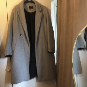 Kappa - Grå kappa i nyskick. Använd fåtal gånger. Bälte medföljer. Passar S-L beroende på hur oversize du vill ha den.