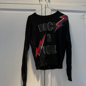 Zadig & Voltaire tröja - Tröja i svart kashmir med blixtar. ”rock & roll” text. 