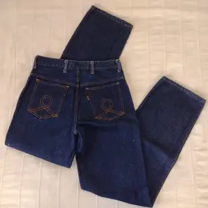 Mörkblå jeans - vintage från José. I fint skick bortsett från två små hål på baksida lår. 100% bomull. Innerbenslängd ca 81 cm och ca 36 cm breda mätt tvärs över i ovankant. 