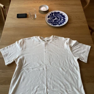 Arket t-shirt i bouclé - En fin tröja i bouclétrikå vilket känns lite som frotté. Skick 10/10 aldrig använd. Storlek L men passar mer xl. Hör av dig vid frågor! Priset är inte hugget i sten