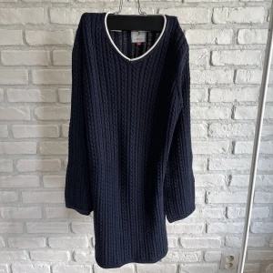 Stickad marinblå klänning  - Kabelstickad marinblå klänning i barnstolen XL. V ringar och utan skador. 