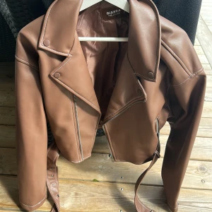 Höstjacka brun!  - Kort brun oversized skinnjacka från Nelly i kollektion med Bianca Ingrosso! Storlek 34. Använd 1 gång. Jag är strl S/M, men 34 funkar bra i denna - beror på vilken passform man vill ha! 