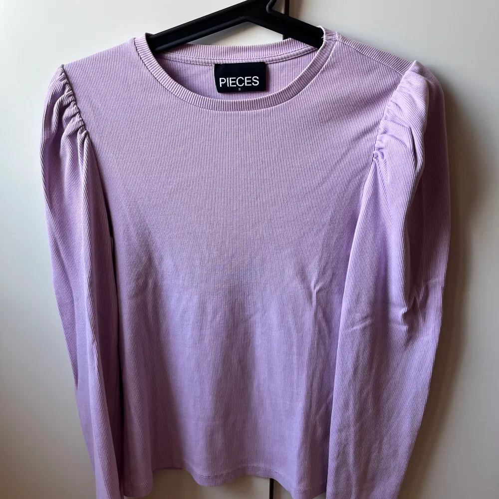 En långärmad tröja med puffärm i en lila/rosa färg. Storlek S. Knappt använd.. Tröjor & Koftor.