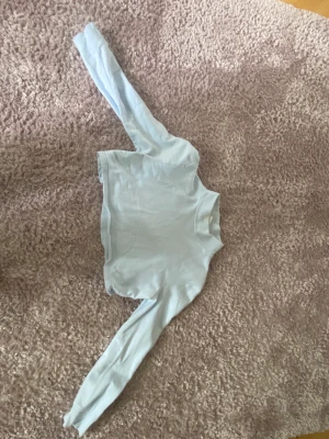 Croppad tröja från monki - Här är en superfin ljusblå croppad tröja från monki. Har en supereliten svart fläck (se bild 3) som knappt syns om man inte kolla väldigt nära! Älskar denna tröja men den kommer ej till användning längre❤️