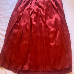 Superfin plisserad röd kjol från Franck Oliver i 100% siden. Knapp i midjan. Knappt använd, nyskick. S/M