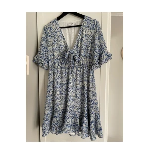 Blå-blommig somrig klänning ! - Supersöt blå klänning ! Storlek 40 men en aning liten i storlek så mer en 38! Köpt på NA-KD 2021 men knappt använd. Säljer pgr av använder inte!  Passar perfekt till sommaren!  