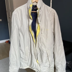 Vindjacka - Fin beige vindjacka från u.s polo assn köpt second hand men knappt använd. I mycket gott skick. Går att öppna upp dragkedja för luva. Praktisk med massa fickor med dragkedjor:)