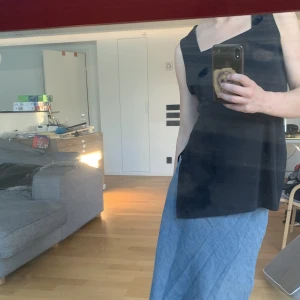 Långt linne - Svart långt linne med skärningar på sidorna.