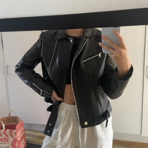 Skinnjacka NA-KD - Skinnjacka från NA-KD, några åt gammal men bara använd ett fåtal gånger. Svart med silvriga detaljer. Alla dragkedjor och knappar funkar som dom ska. Väldigt bra skick. 