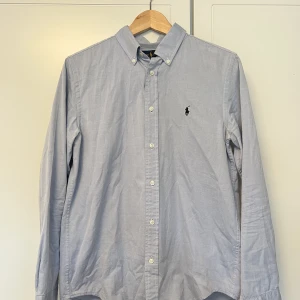 Skjorta, ljusblå från Ralph Lauren - Barnstorlek 20, ungefär S i vuxen. 