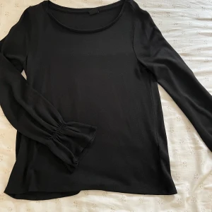 Svart blus - En svart blus med volang i nyskick från GinaTricot, super skön! 