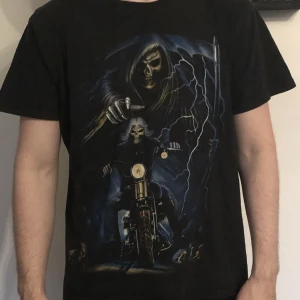 T shirt med tryck i stl L. Svart T shirt - Denna T shirt med tryck är stl L och är gjord av bomull. Den är i fint skick.