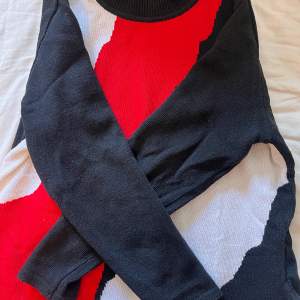 Abstrakt mönster med färgerna vit, röd och svart. Finstickad tröja köpt second hand. Tyvärr är storlekslappen avklippt men skulle säga storlek m, jag är 177cm. 